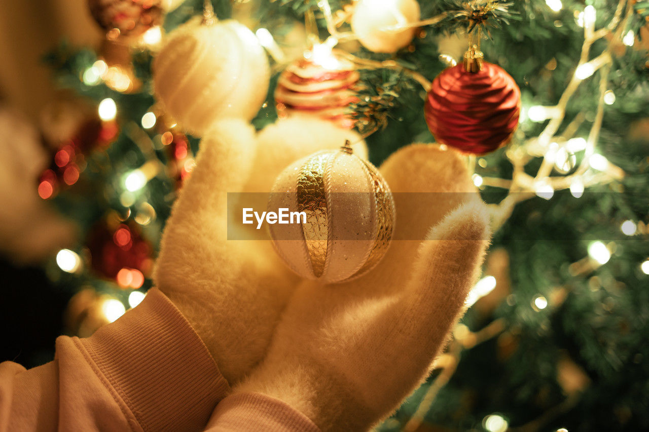 holiday, christmas, tree, celebration, christmas tree, decoration, christmas decoration, tradition, christmas ornament, plant, christmas lights, one person, illuminated, hand, indoors, event, gift, lifestyles, close-up, nature, hanging, religion, focus on foreground, holding, adult