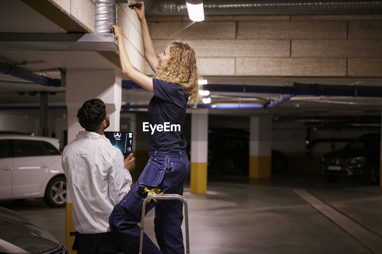 Man and woman checking air duct