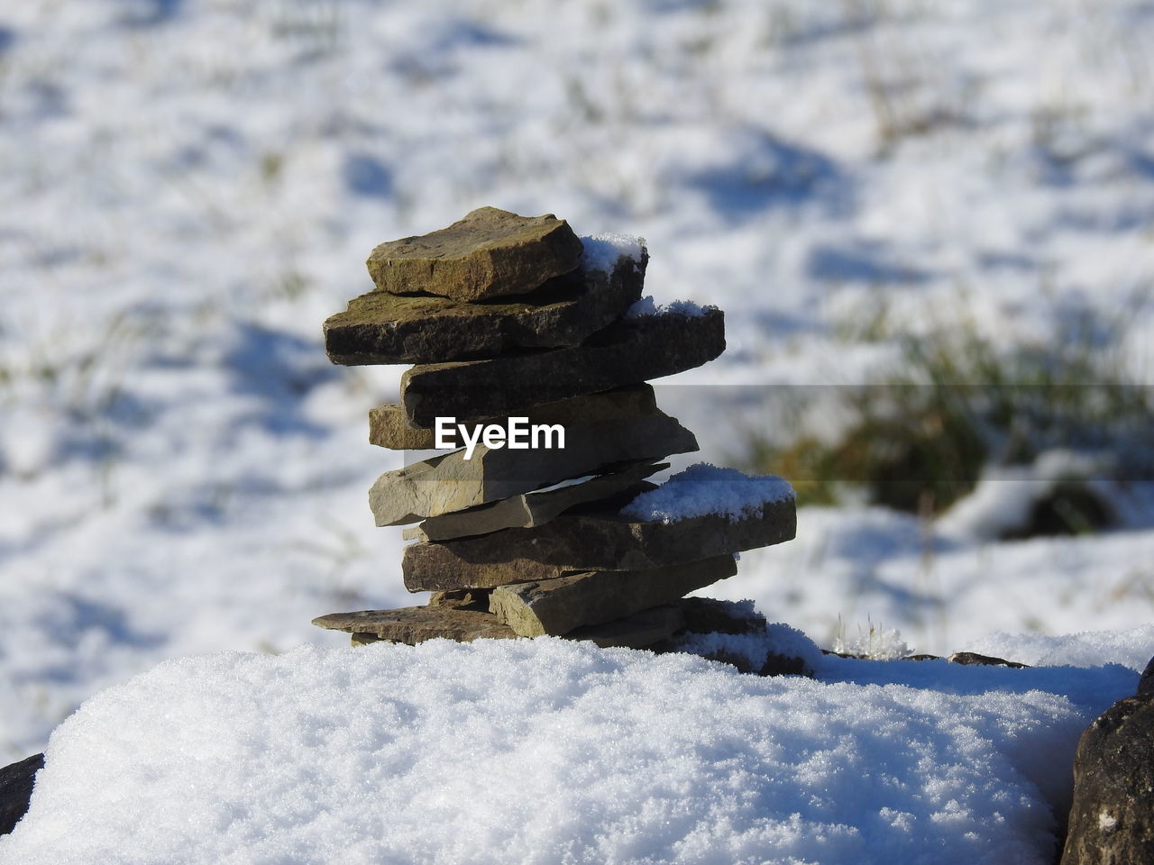 CLOSE-UP OF STACK ON SNOW COVERED LAND