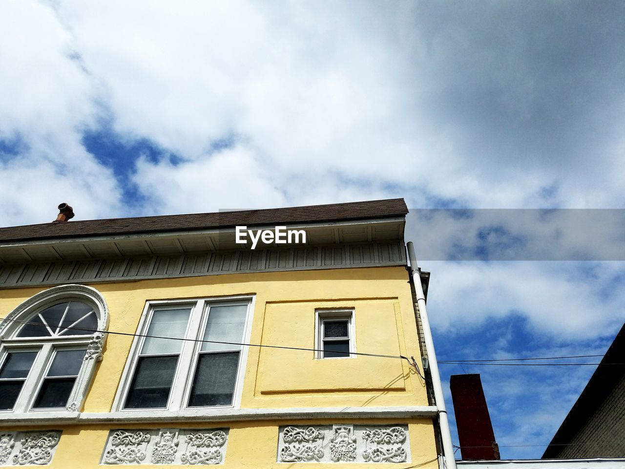 Low angle view of yellow building against sky