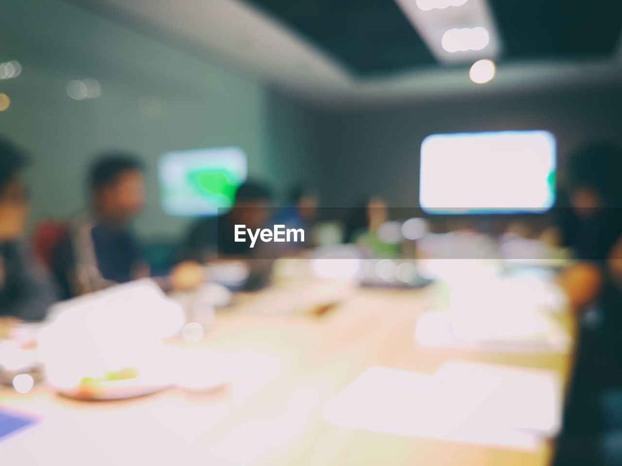 Defocused image of business colleagues having meeting at conference table 