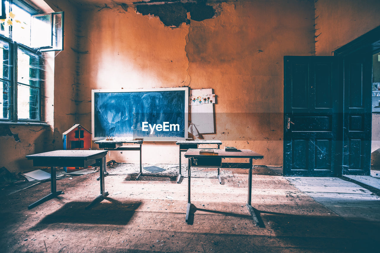 Empty chairs and table in abandoned building