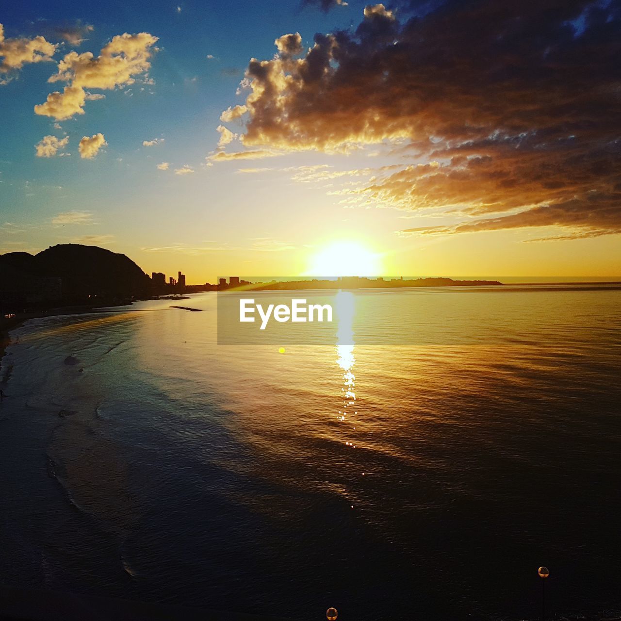 SCENIC VIEW OF BEACH AGAINST SKY DURING SUNSET