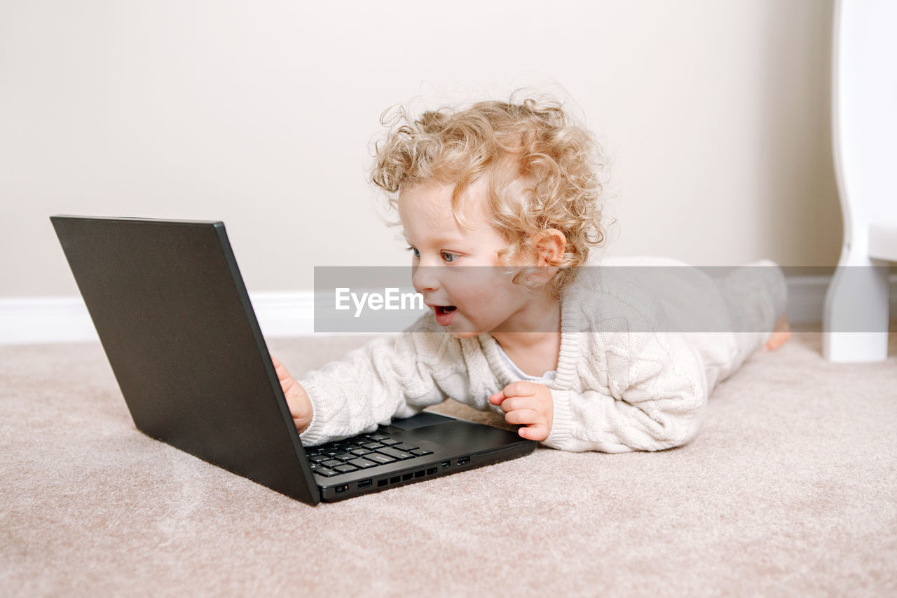 Toddler baby boy working on laptop. little kid child using technology. early age education 