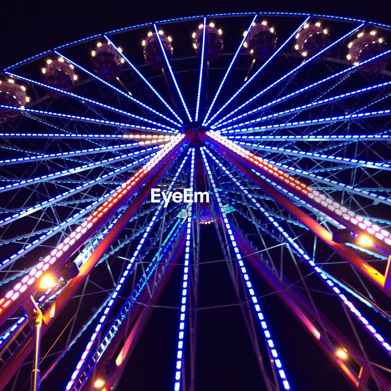 LOW ANGLE VIEW OF ILLUMINATED FERRIS WHEEL AT NIGHT