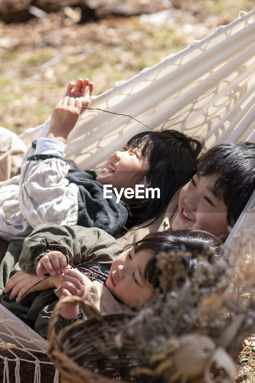 Cute kids lying on hammock outdoors