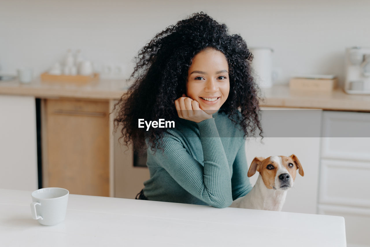 Smiling woman with dog at home