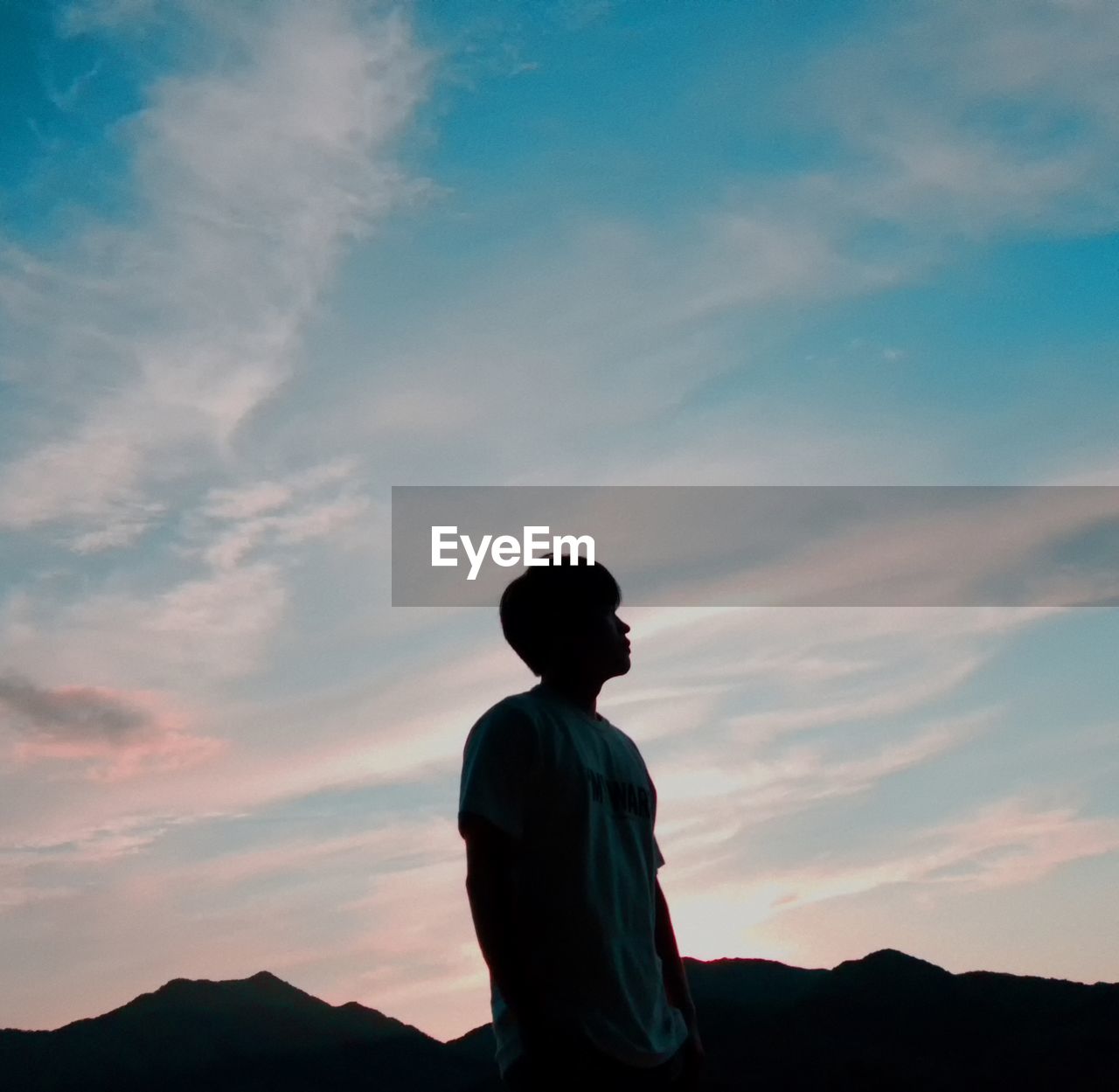 Man standing against sky and mountain during sunset