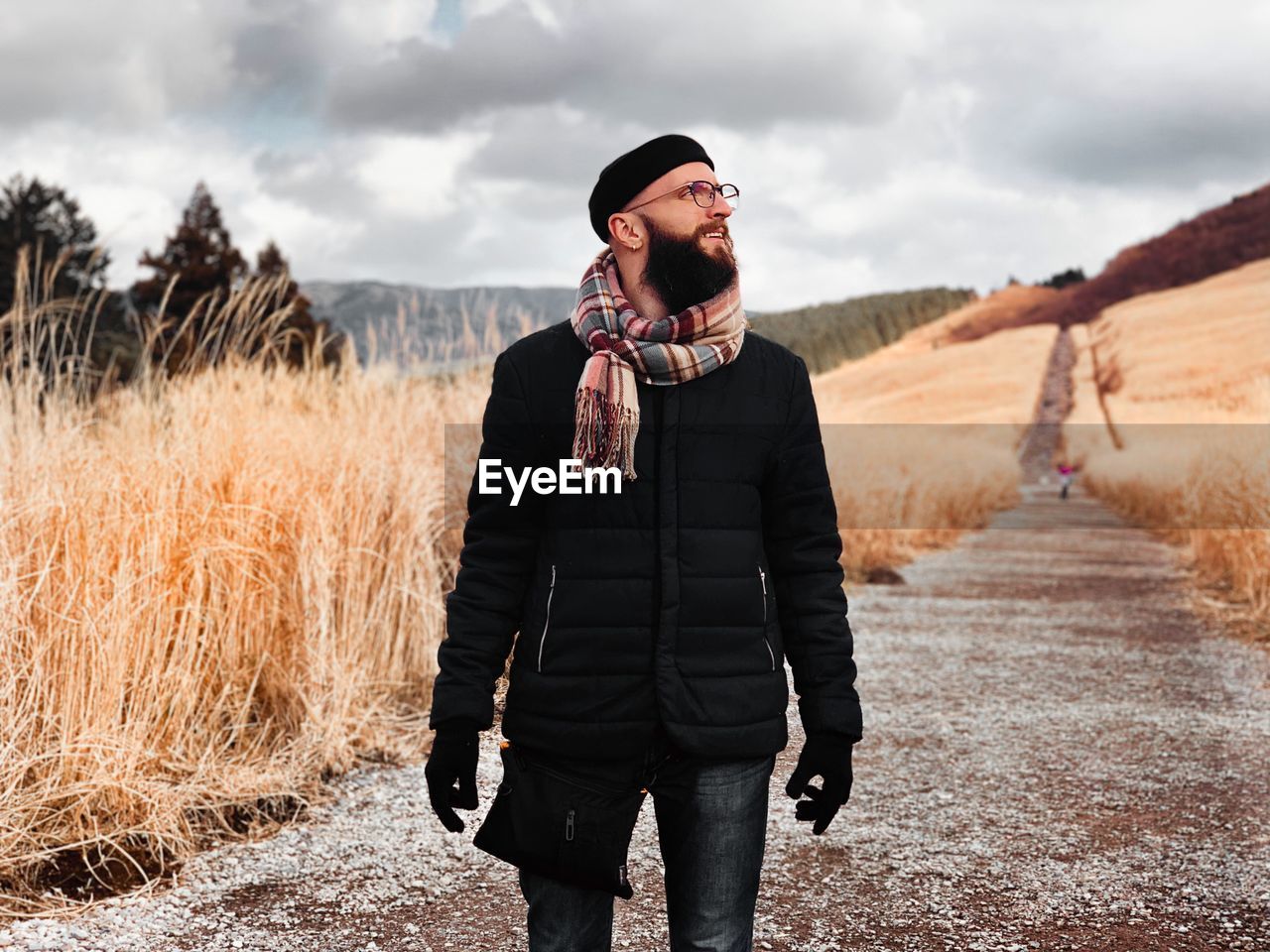 Bearded man in warm clothes walking in the mountains