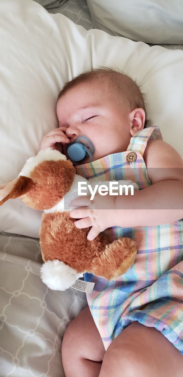 High angle view of baby boy sleeping on bed at home