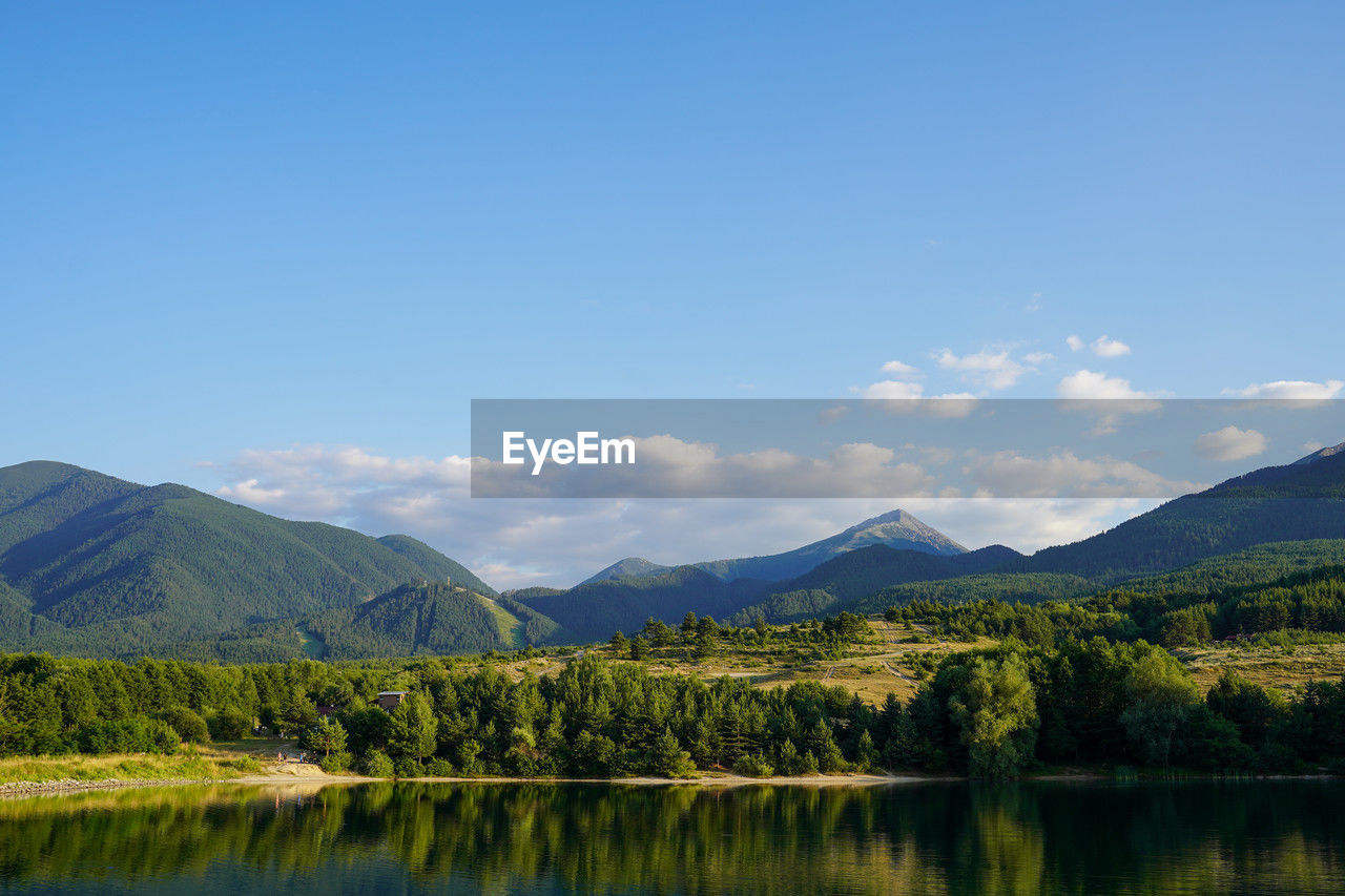 scenic view of lake and mountains against blue sky