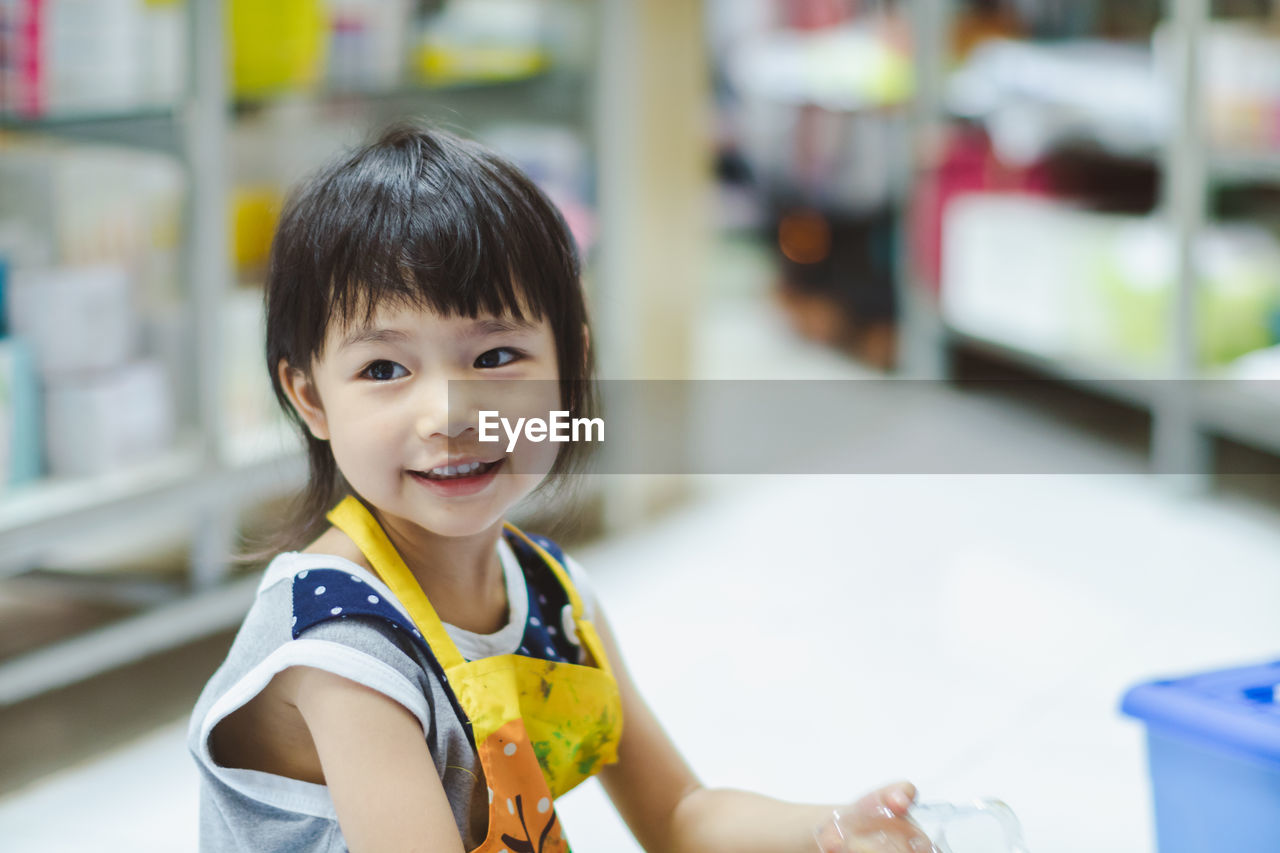 Close-up of smiling girl looking away at home