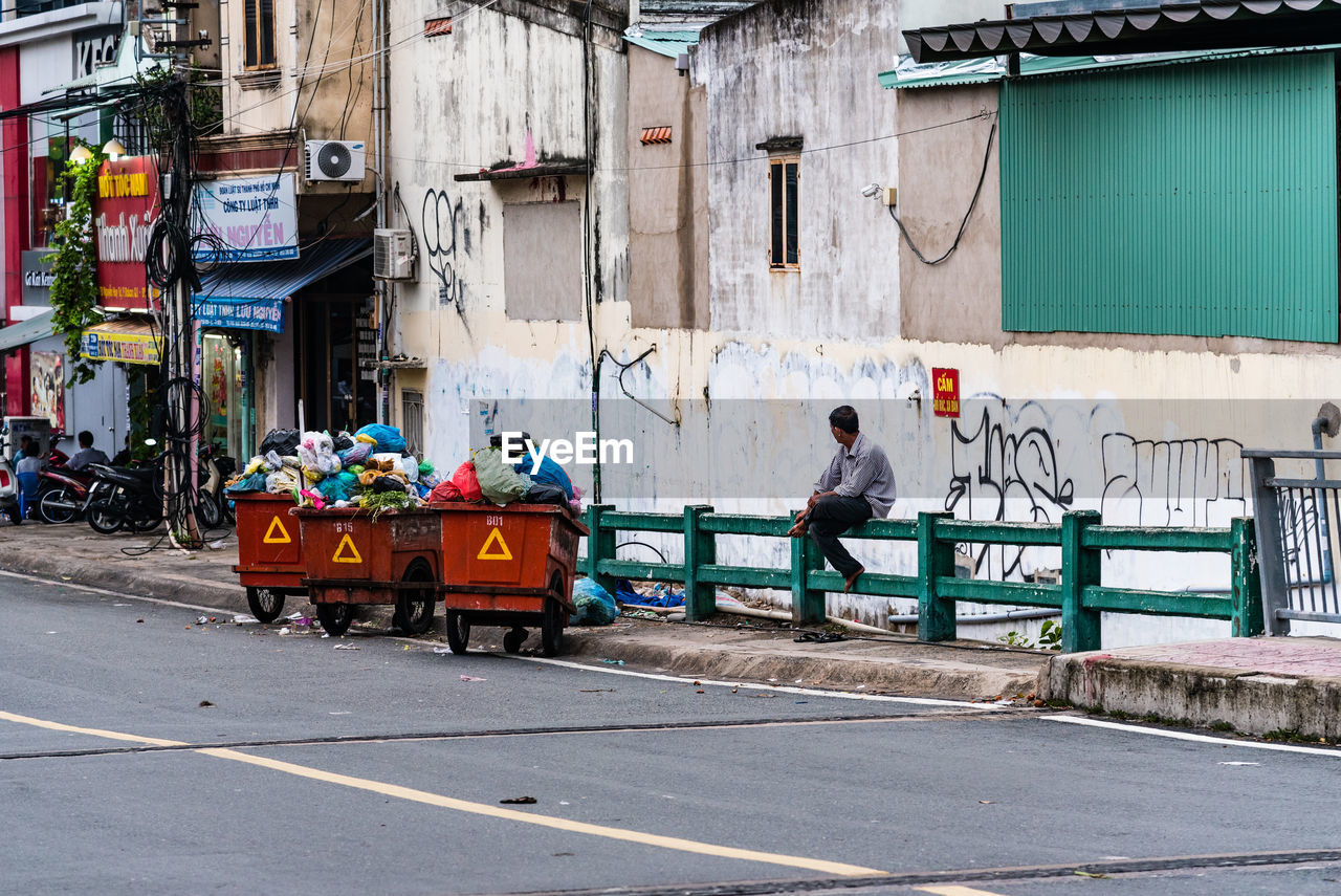 PEOPLE WORKING ON STREET BY BUILDING