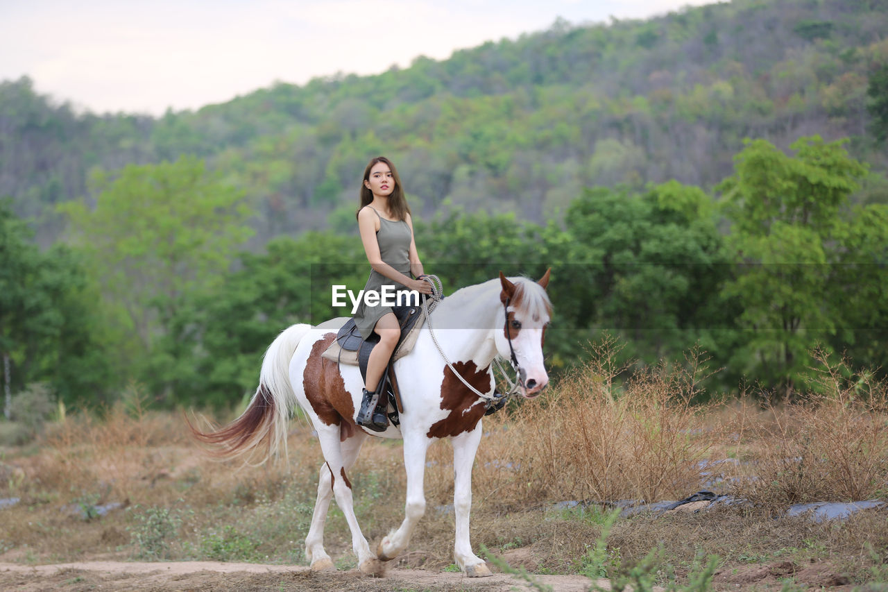 FULL LENGTH OF MAN RIDING HORSE ON LAND