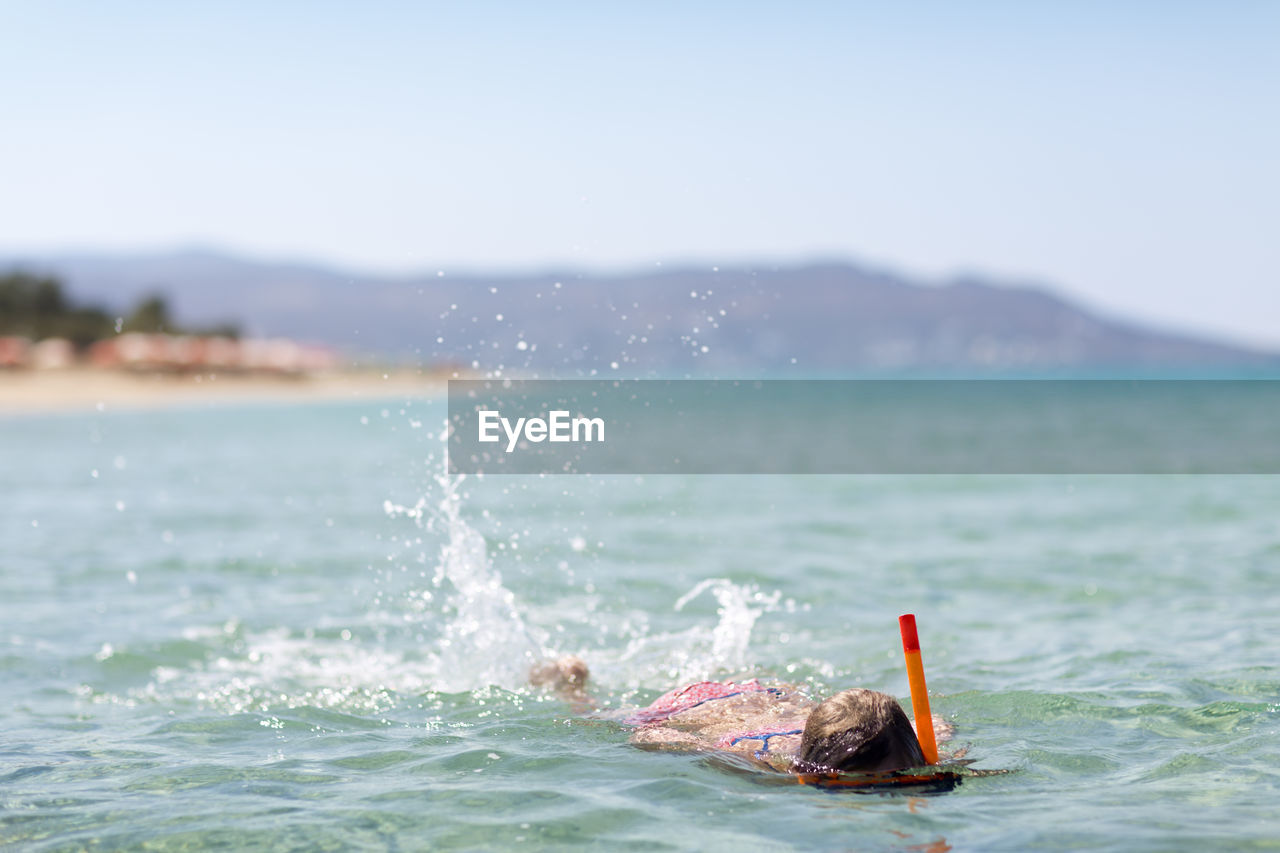 Girl swimming in sea, naxos, greece