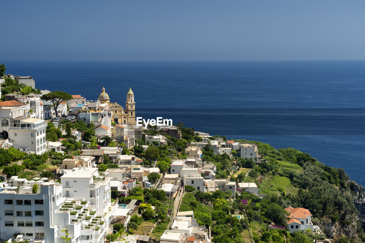 High angle view of townscape by sea against clear sky