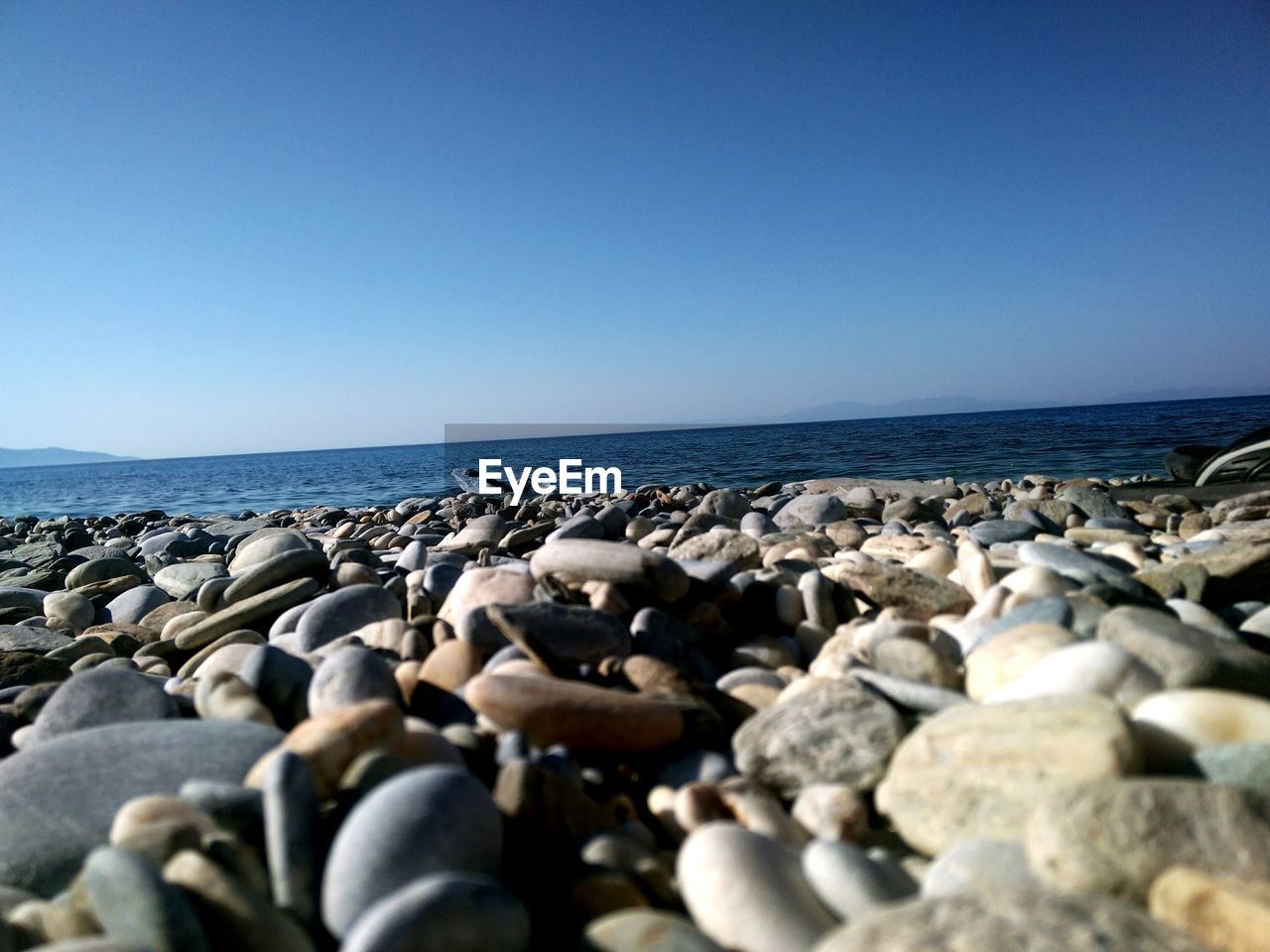 SURFACE LEVEL OF PEBBLE BEACH AGAINST SKY