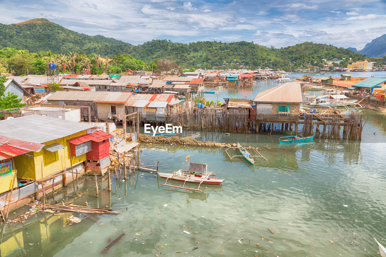 HIGH ANGLE VIEW OF BUILDINGS BY RIVER