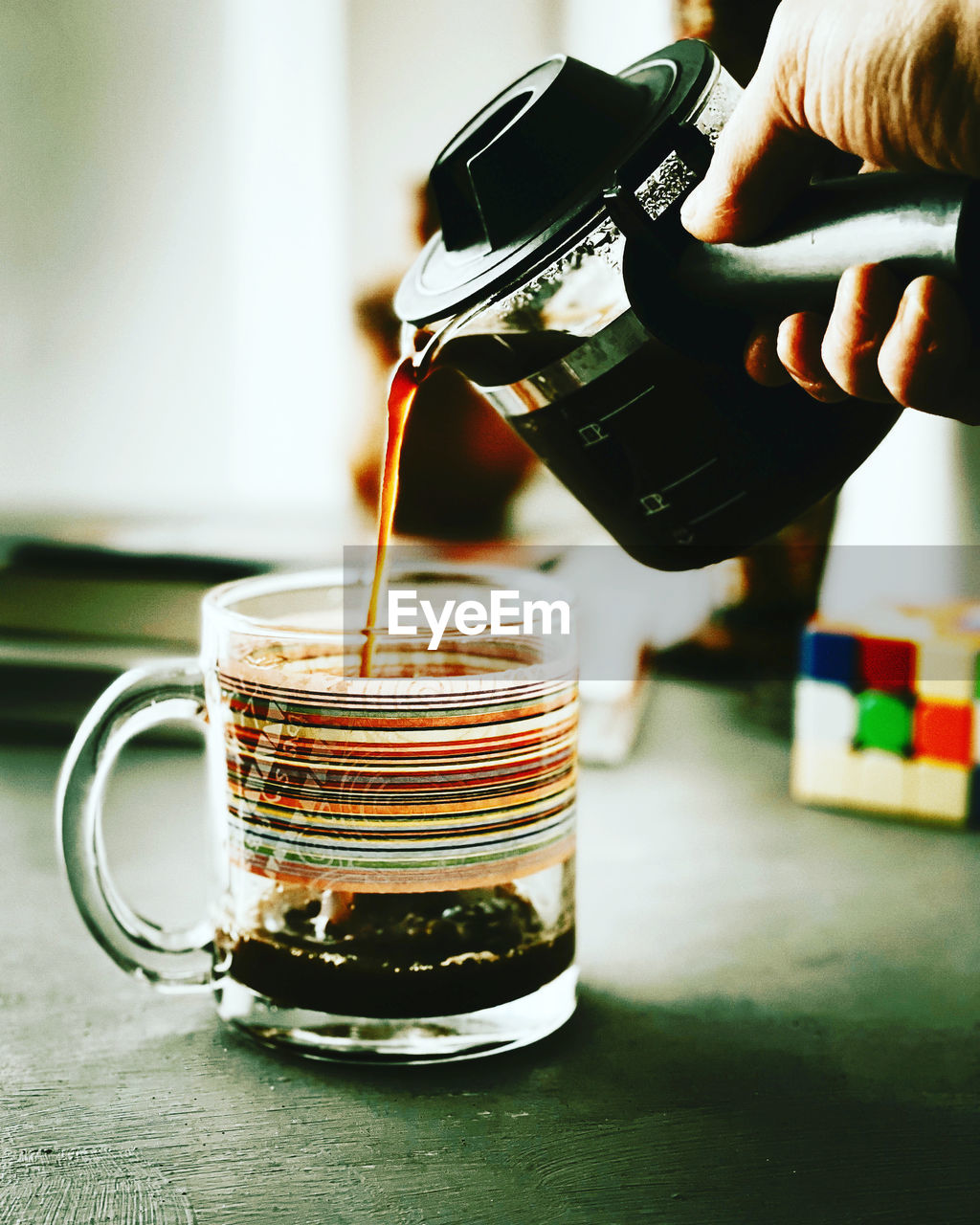 Close-up of hand pouring coffee on table