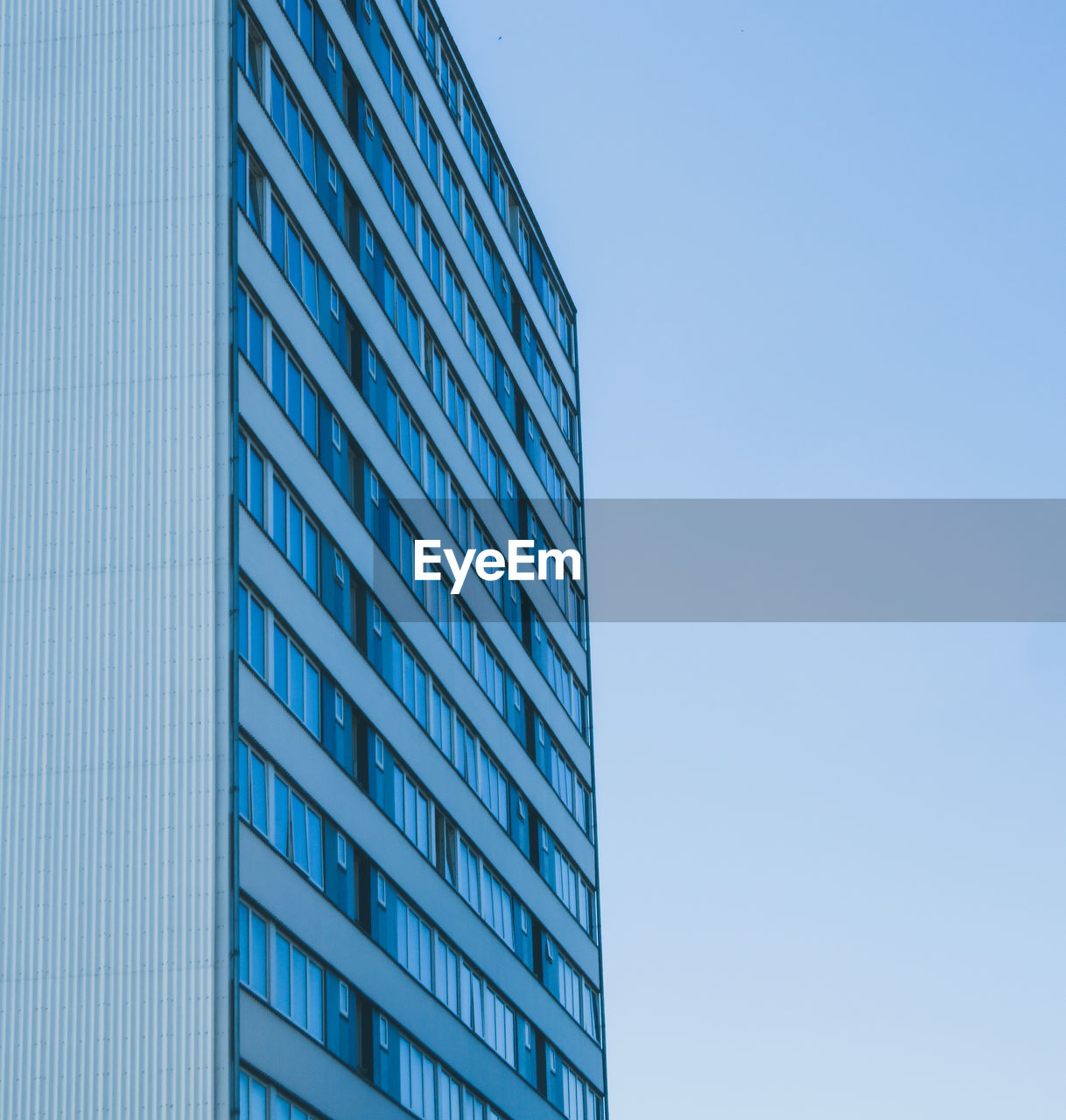 Low angle view of modern building against clear blue sky