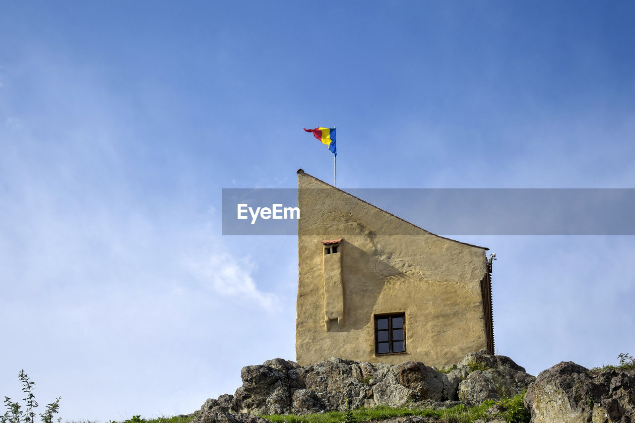 sky, architecture, built structure, flag, nature, building exterior, tower, building, cloud, history, blue, the past, day, no people, patriotism, outdoors, low angle view, travel destinations, environment, plant, land, landscape, copy space, rural area, travel