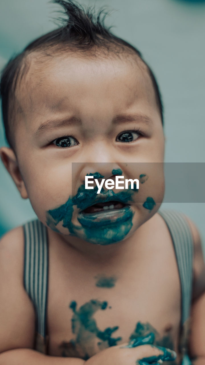 Portrait of cute baby boy with paint on face