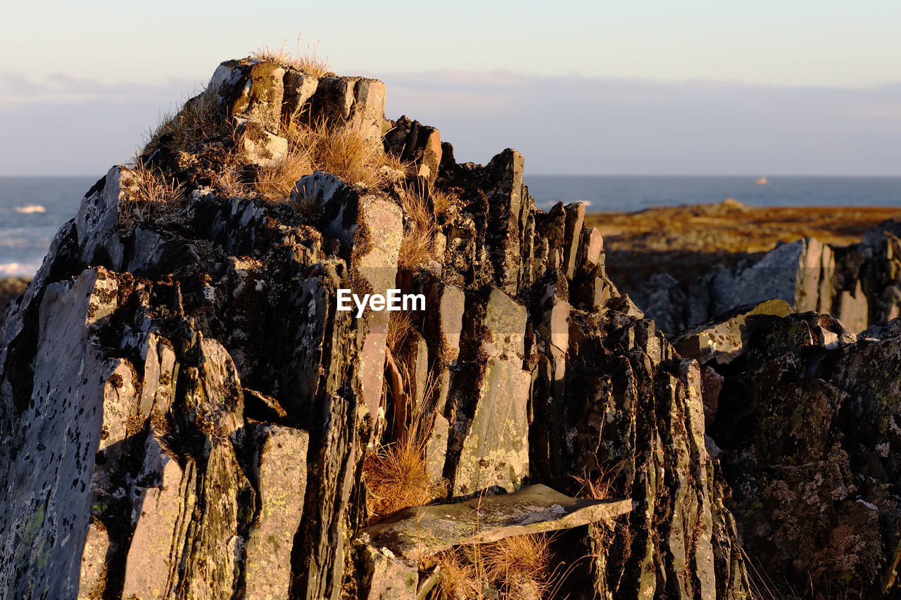 CLOSE-UP OF ROCK FORMATIONS ON BEACH