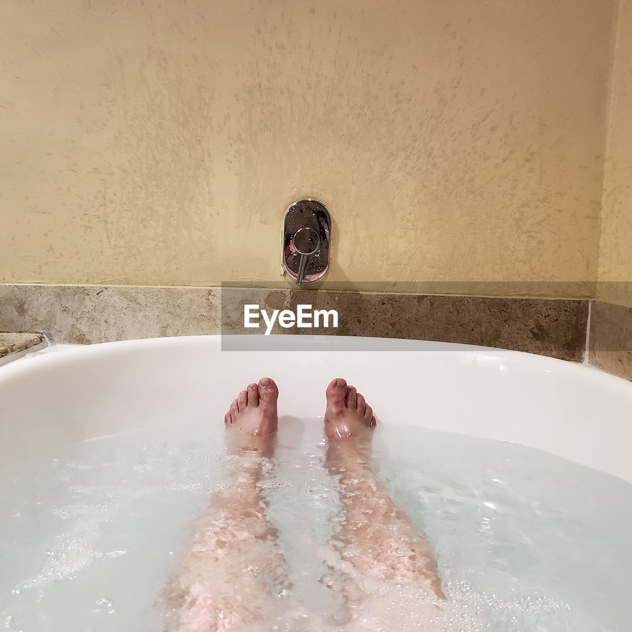 Low section of person in bathtub