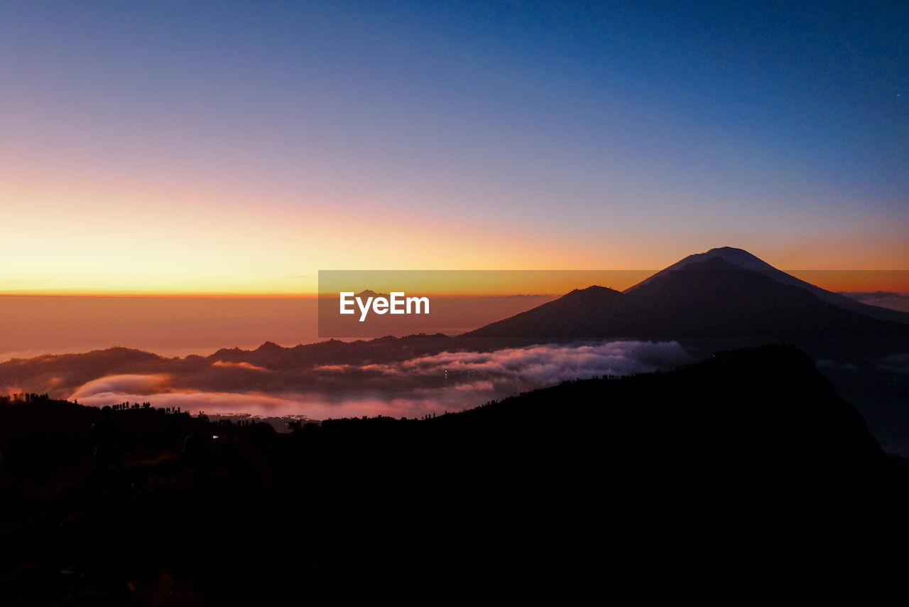 Scenic view of silhouette mountains against sky during sunset