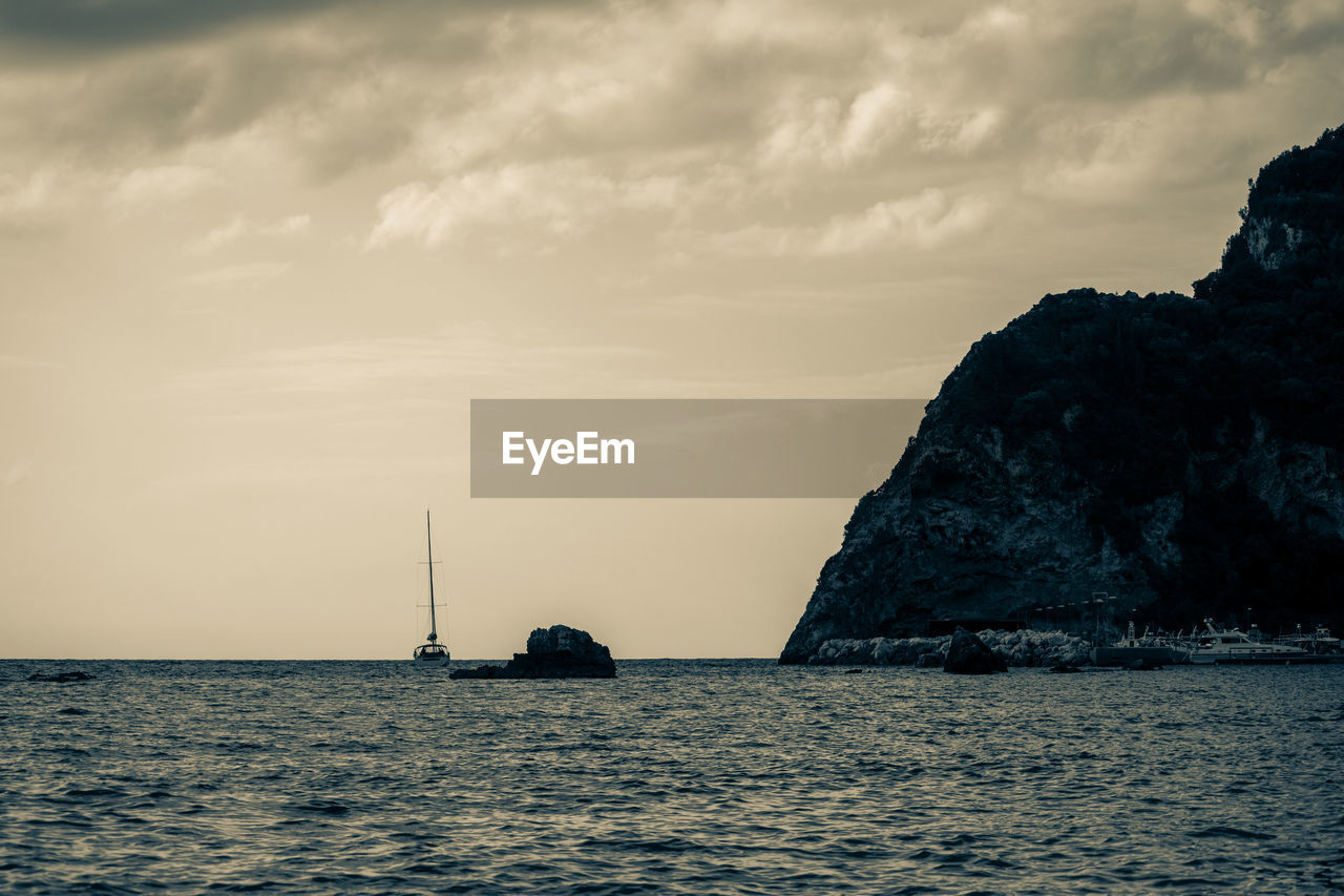 SAILBOAT SAILING ON SEA AGAINST SKY