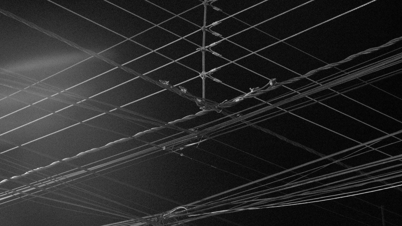 Low angle view of power lines against sky at night