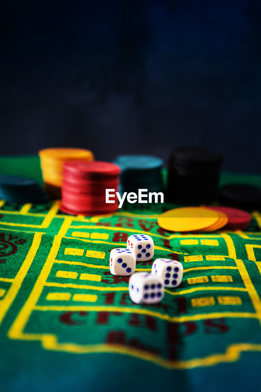 Close-up of gambling chips and dices on table at casino