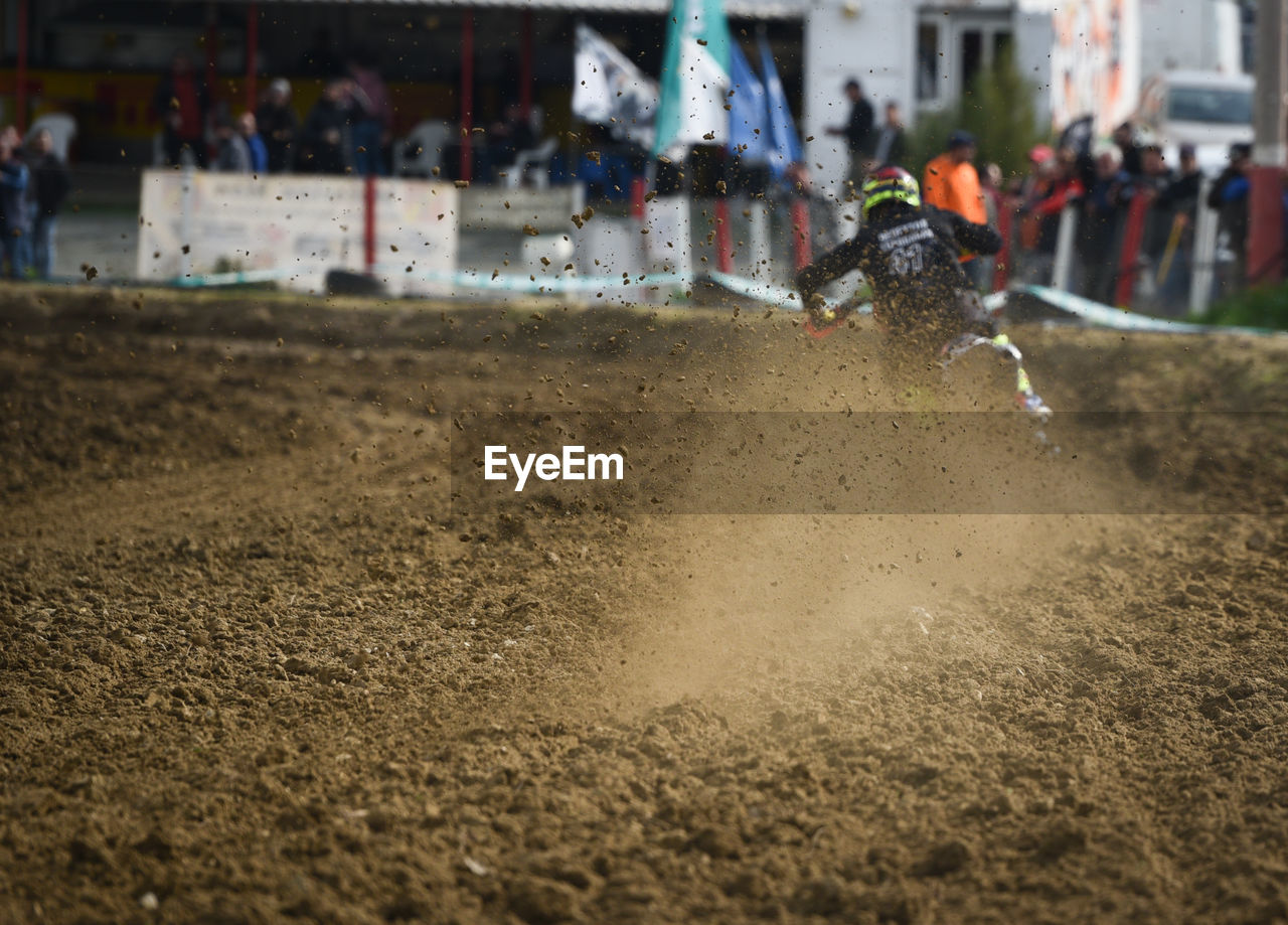 Unrecognized athlete riding a sports motorbike and muddy wheel on a motocross racingt