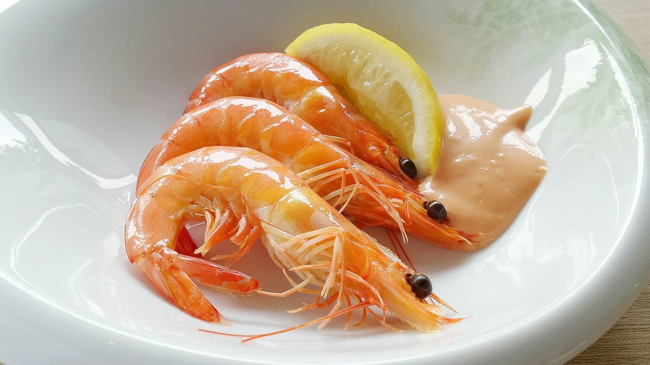 Close-up of prawns with lemon slice in plate