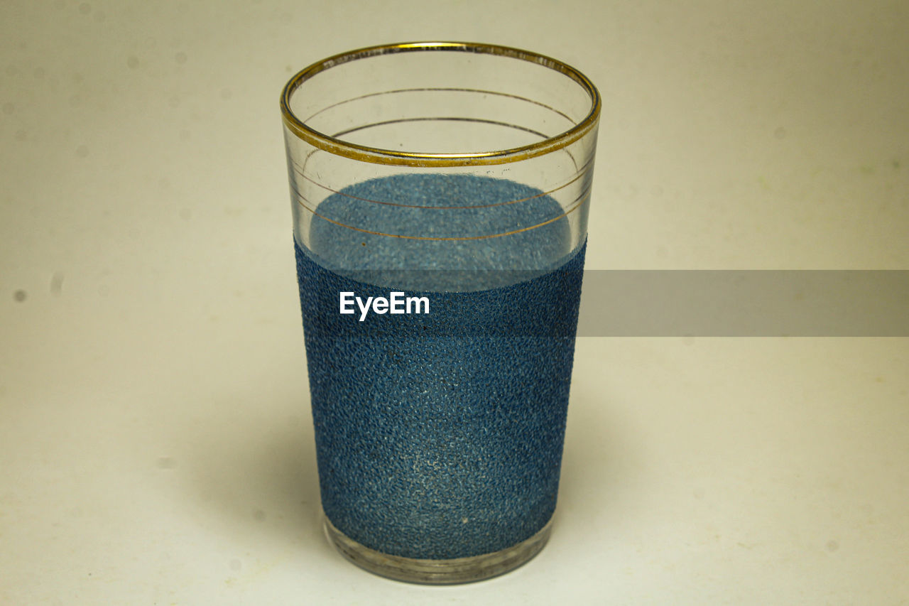 HIGH ANGLE VIEW OF DRINK ON GLASS TABLE