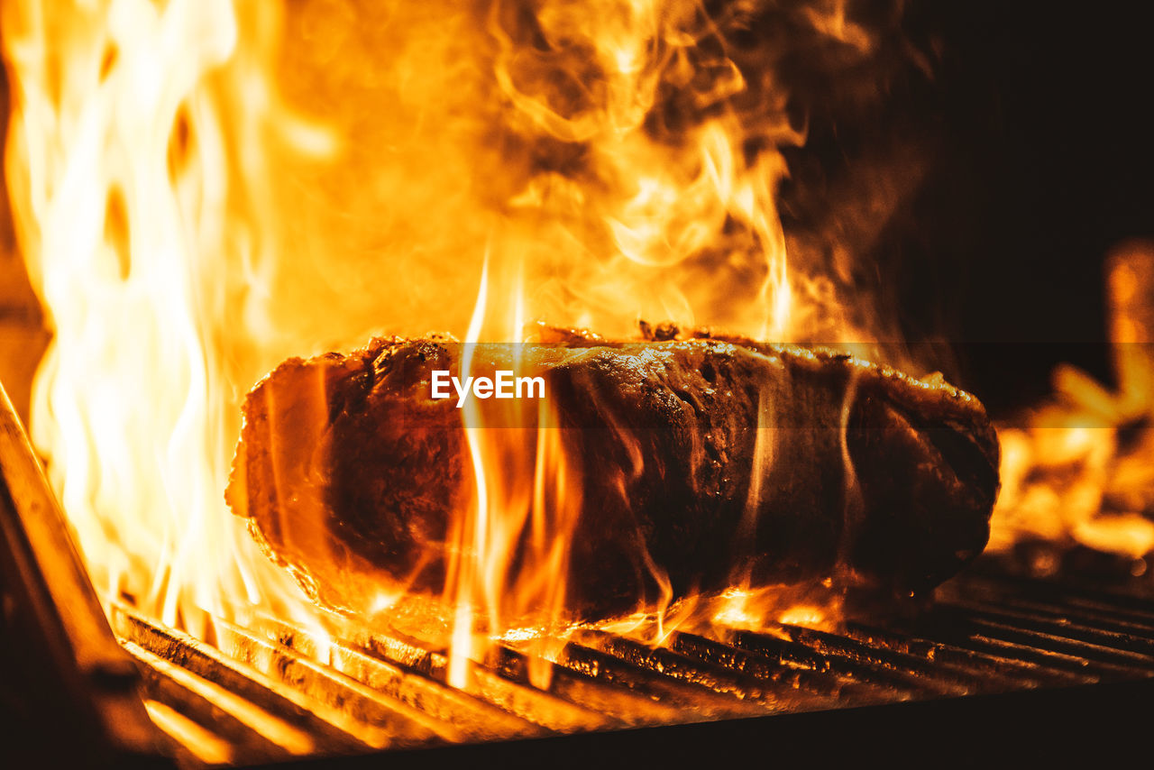 Close-up of meat on barbecue grill at night