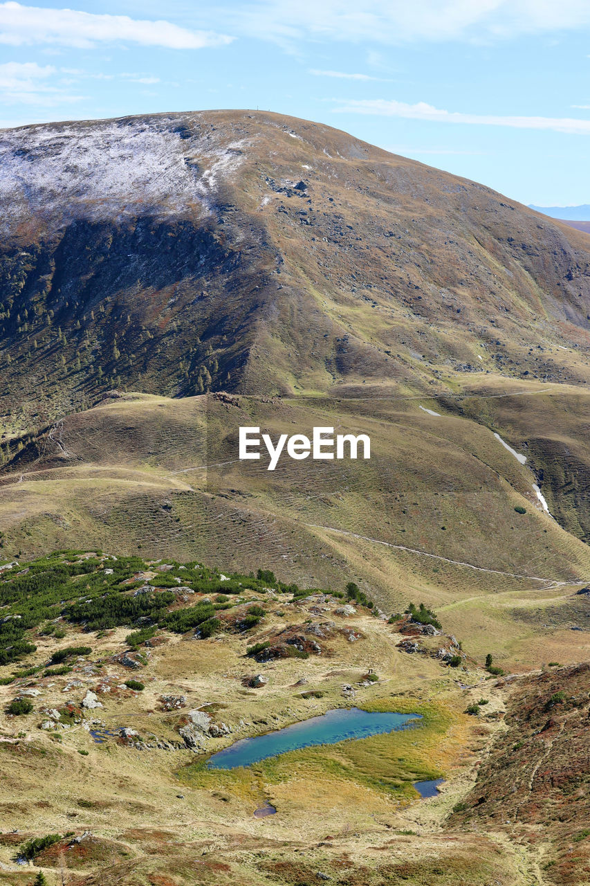 landscape, scenics - nature, environment, beauty in nature, mountain, wilderness, non-urban scene, tranquility, tranquil scene, nature, land, no people, geology, sky, day, cloud, lake, ridge, highland, plateau, outdoors, remote, idyllic, plant, mountain range, travel destinations, physical geography, grass, volcano, travel, rock
