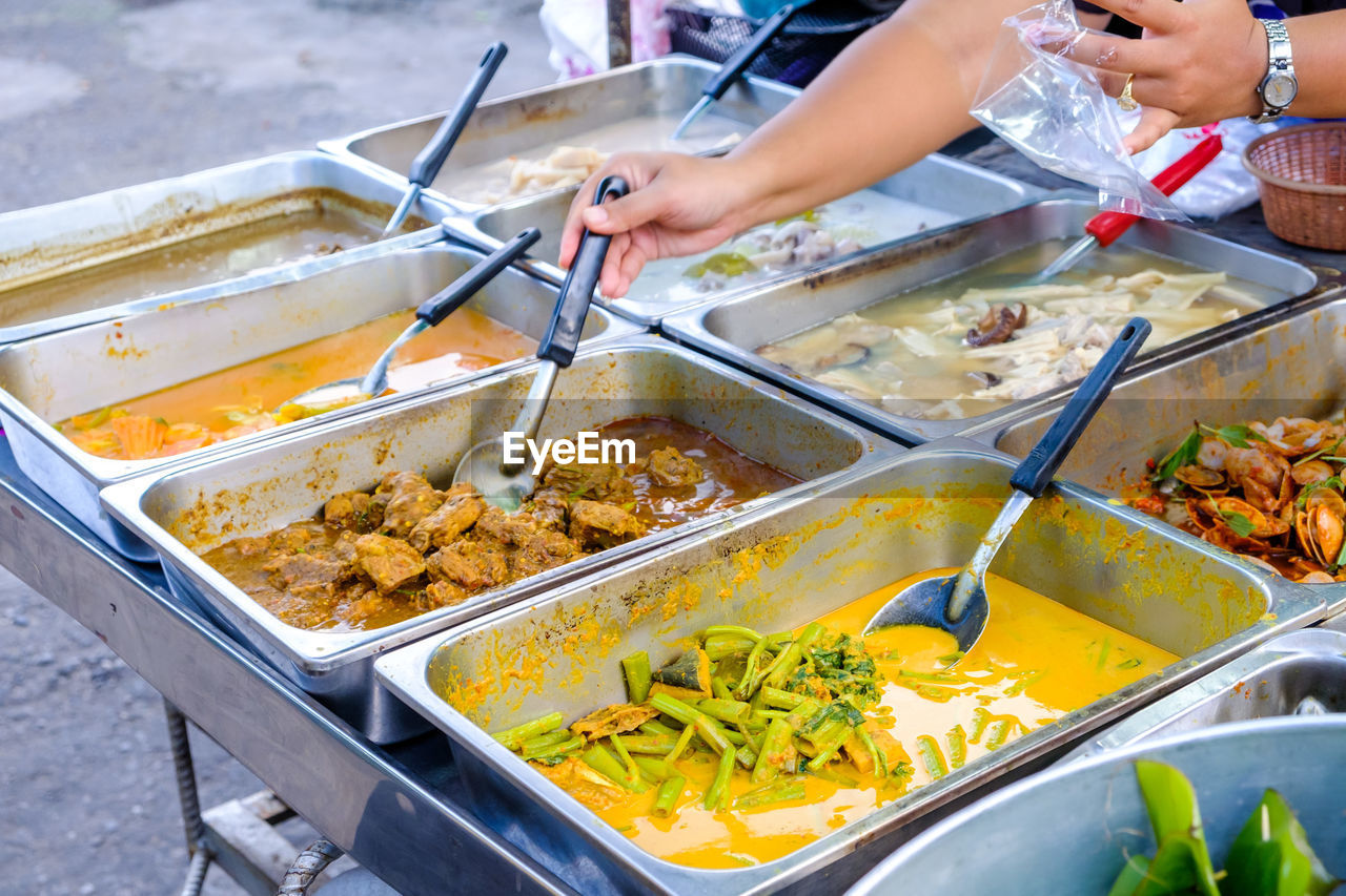 HIGH ANGLE VIEW OF PERSON PREPARING FOOD ON BARBECUE GRILL