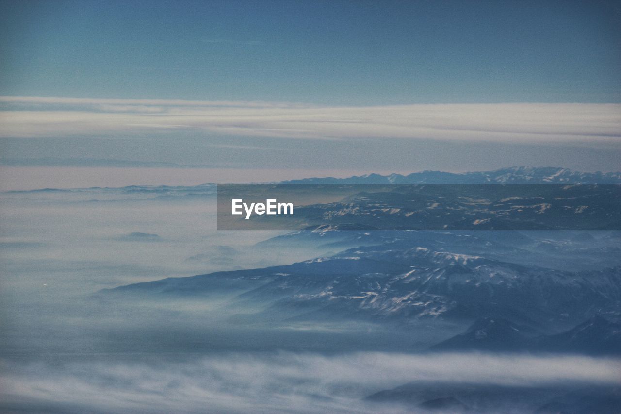 Aerial view of mountains against cloudy sky