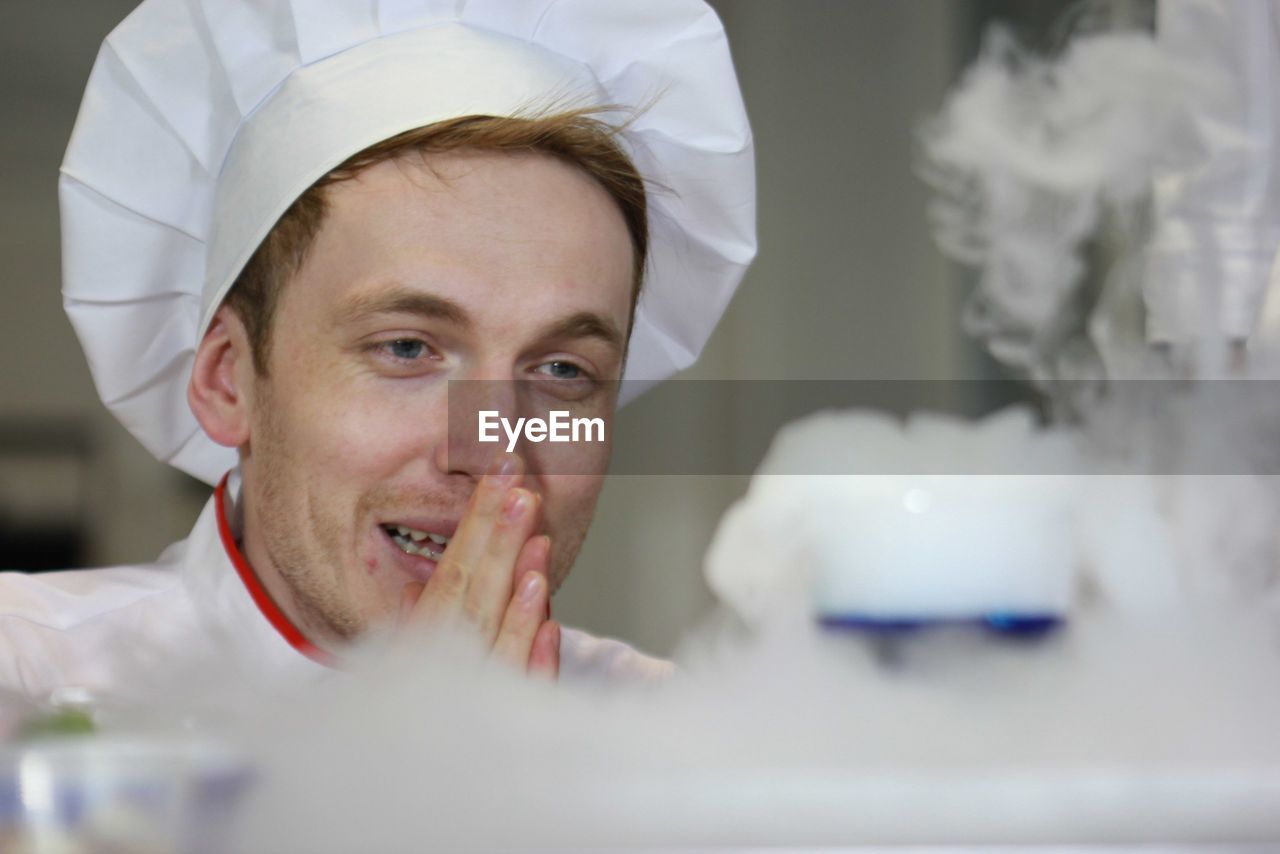 Happy chef looking at dessert in kitchen