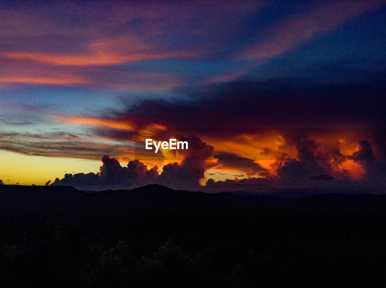 SCENIC VIEW OF SILHOUETTE MOUNTAIN AGAINST DRAMATIC SKY