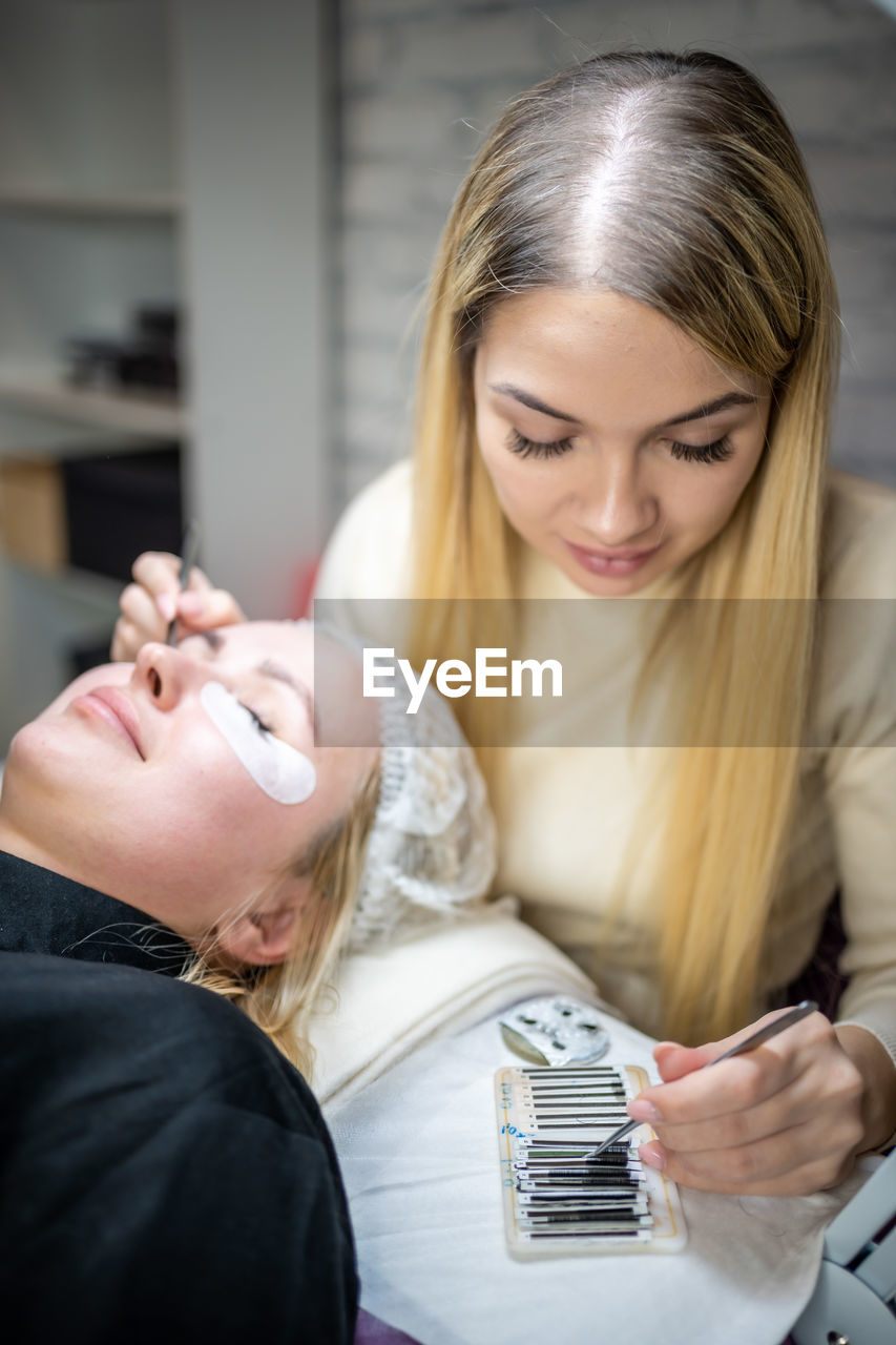 Woman applying eye path to customer