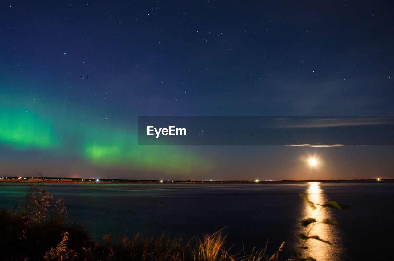 Scenic view of lake against sky at night