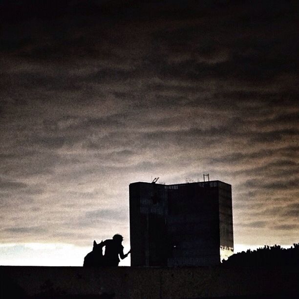 LOW ANGLE VIEW OF BUILT STRUCTURES AGAINST SUNSET