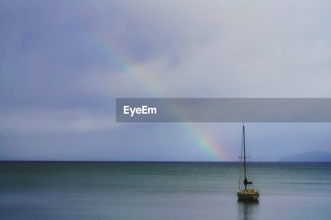 Scenic view of rainbow over sea against sky