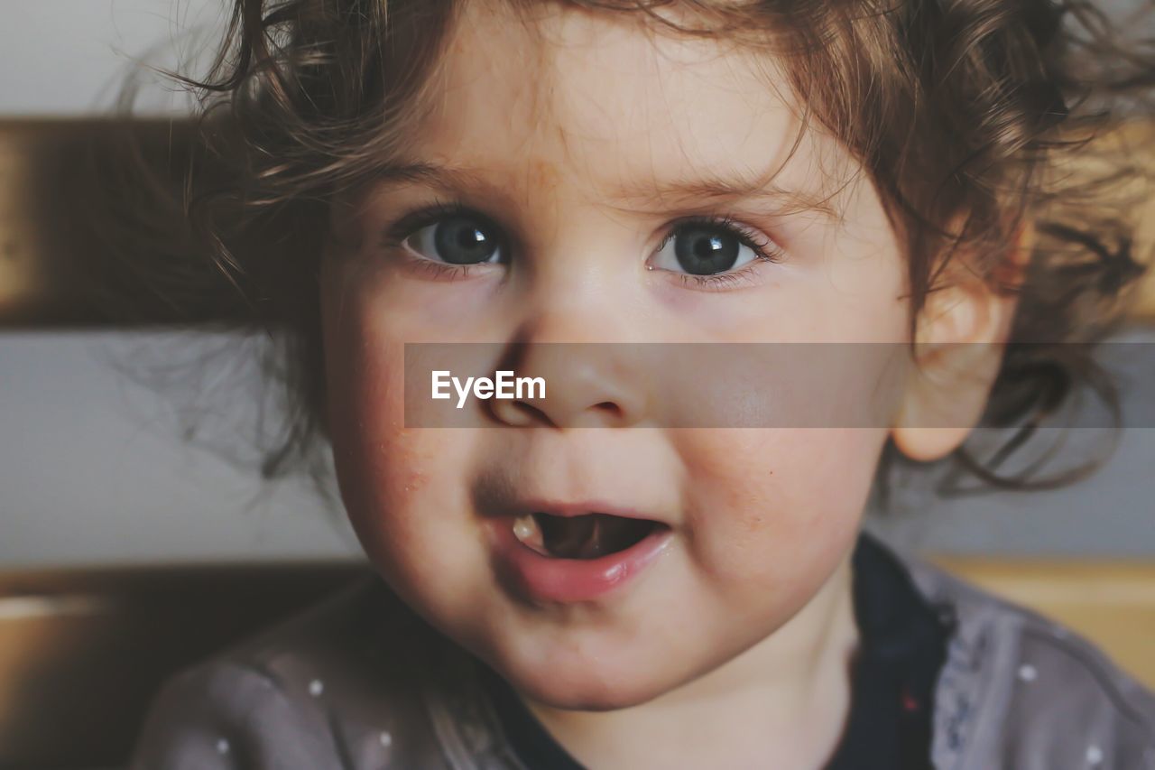 Close-up portrait of cute baby girl sitting on chair