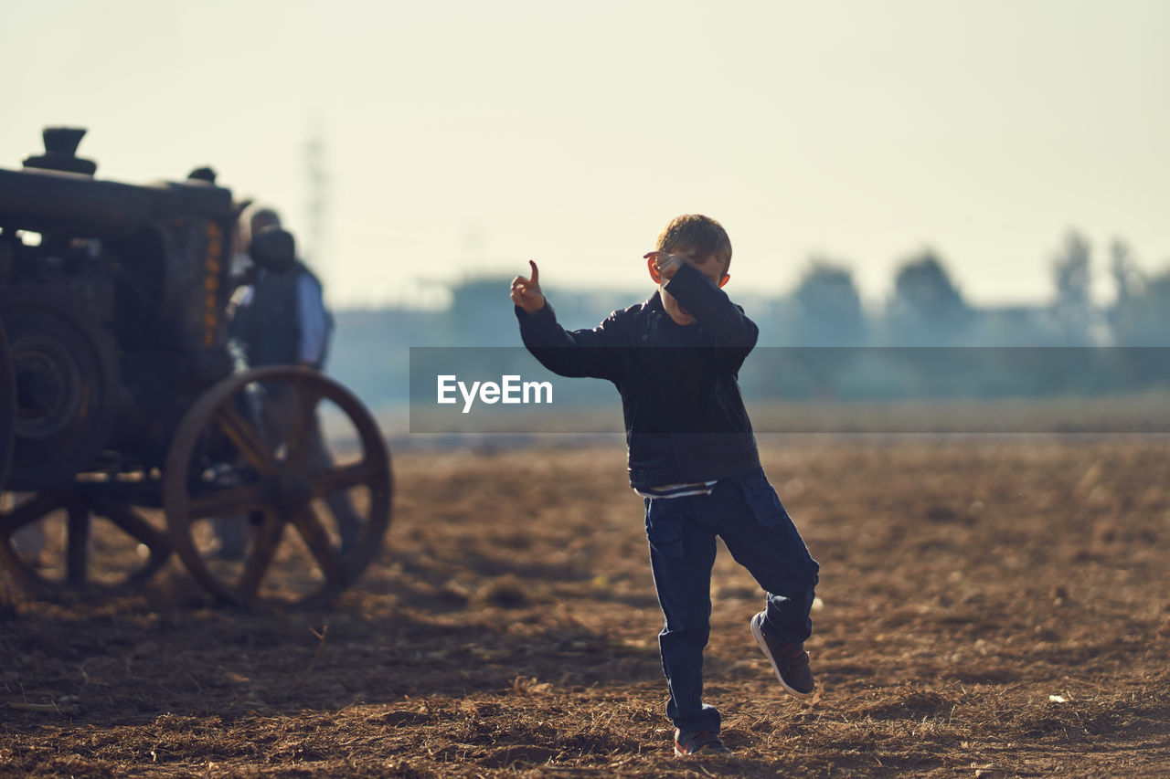 Boy dancing on dirt field