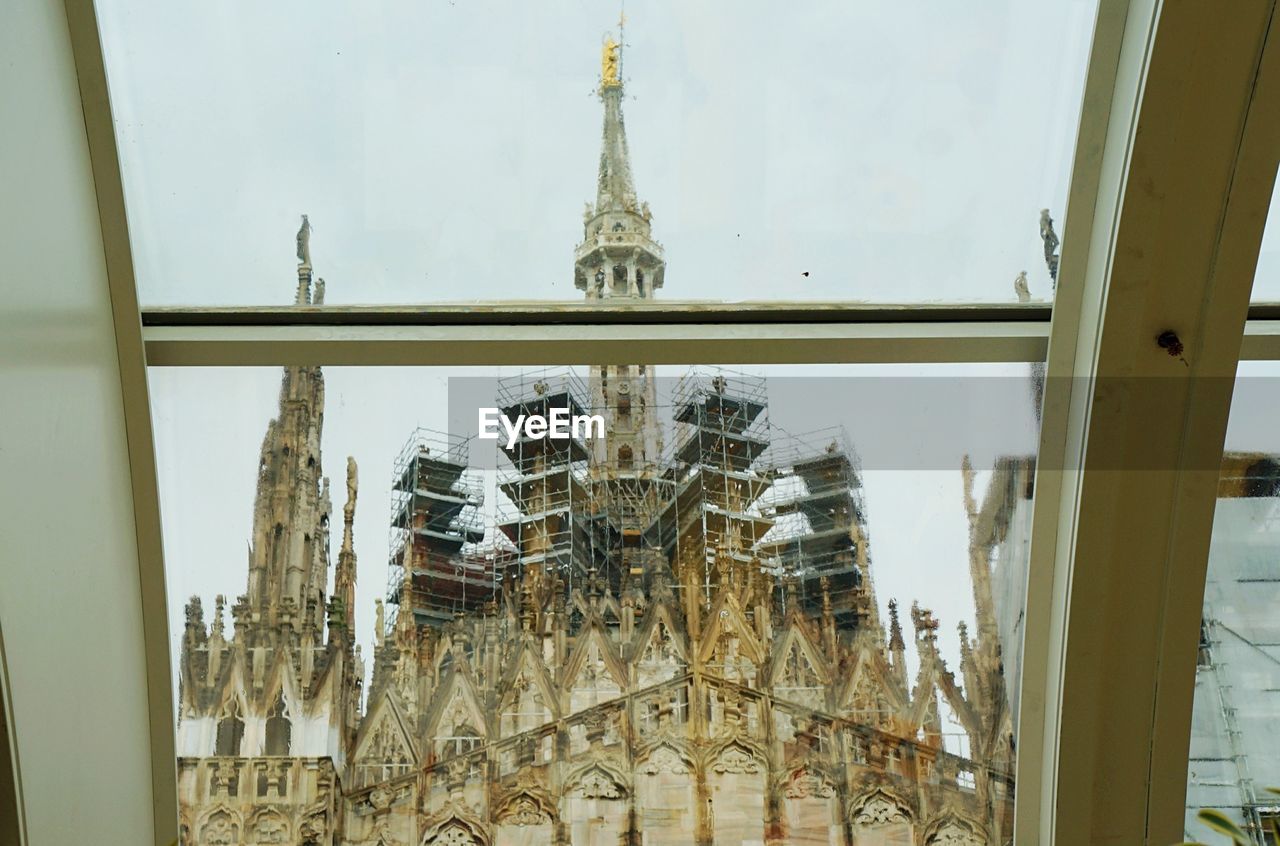 Low angle view of milan cathedral against sky seen from skylight