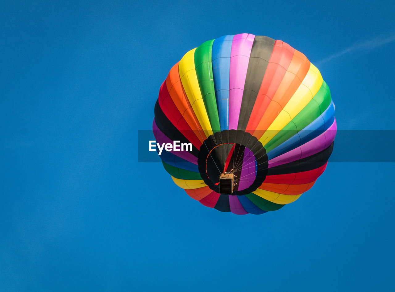 LOW ANGLE VIEW OF HOT AIR BALLOON FLYING AGAINST BLUE SKY