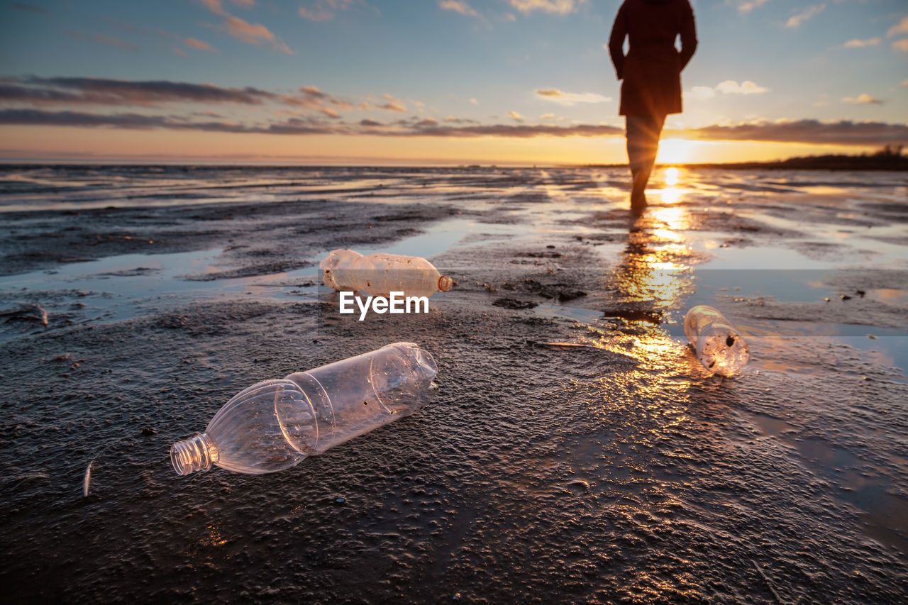 Plastic bottles thrown ashore and the man in the background